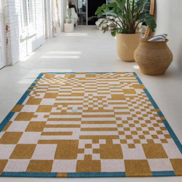 Louis De Poortere Chess rug in gold and cream with blue border on a modern white floor