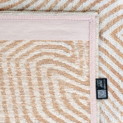 Close-up of Louis De Poortere Coral rug showing detailed beige and white geometric pattern with stitched edges