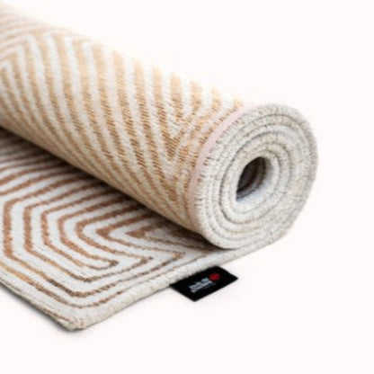 Rolled Louis De Poortere Coral rug luxury beige geometric pattern with visible brand tag