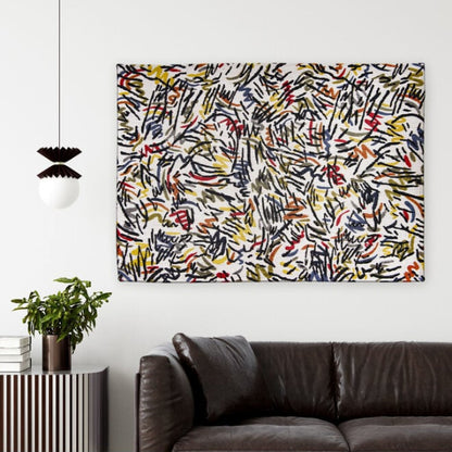 Louis De Poortere Dora and Graffito rug with abstract multicolour pattern displayed on a white wall above a dark brown leather sofa