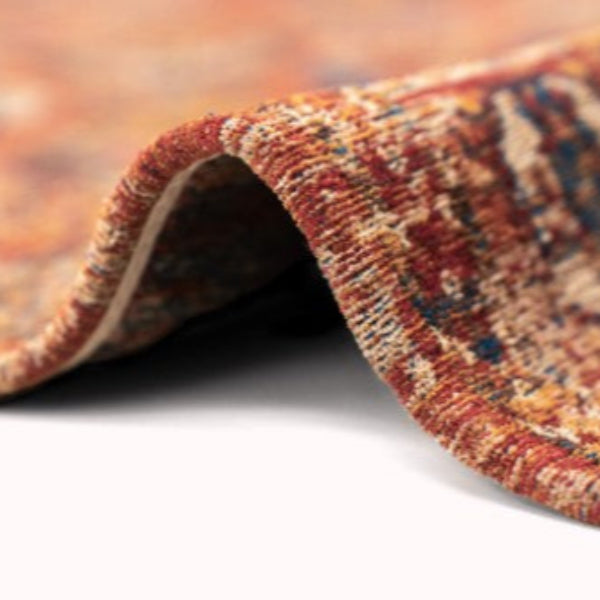 Close up of folded luxury Louis De Poortere Kasak rug showing detailed red and blue pattern