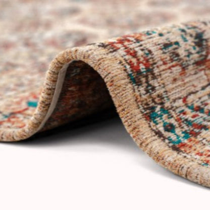 Close-up of a folded Louis De Poortere Kasak rug showing intricate multicolour patterns and texture