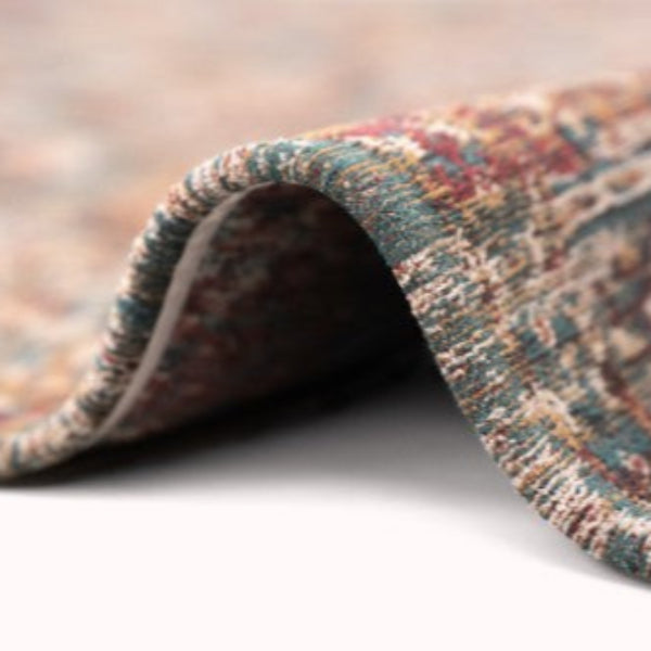 Close-up of folded luxury Louis De Poortere Kasak rug showing detailed woven texture and colours