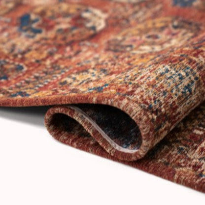 Close-up of a folded Louis De Poortere Kasak rug showing intricate traditional patterns and rich colours