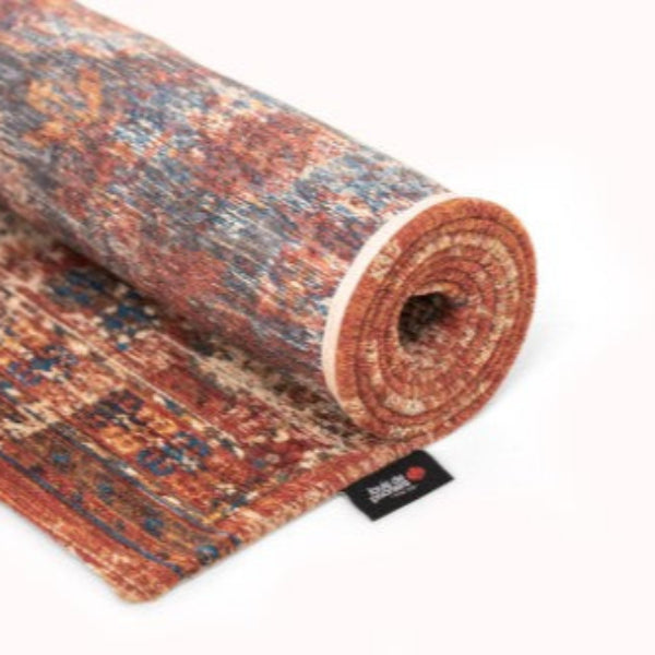 Rolled Louis De Poortere Kasak rug showcasing intricate traditional patterns in warm earthy tones
