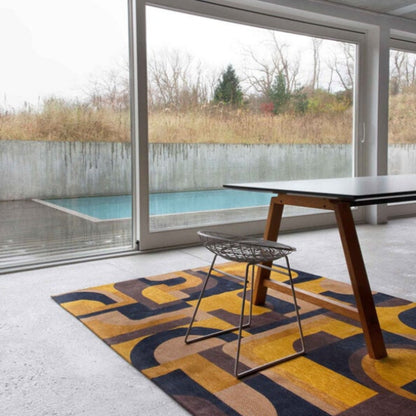 Louis De Poortere Module rug with bold geometric patterns in yellow and black under a modern table and wire chair