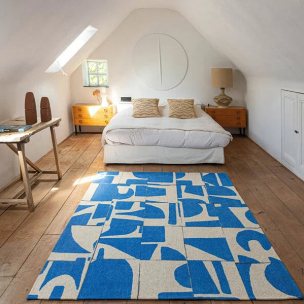 Louis De Poortere Papercut rug with blue and cream abstract design in a modern bedroom
