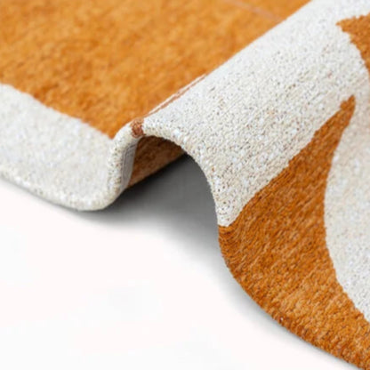 Close-up of folded Louis De Poortere Papercut rug showing orange and white textured pattern