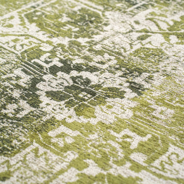 Close-up of a green and cream luxury Louis De Poortere Tabriz rug with intricate floral patterns