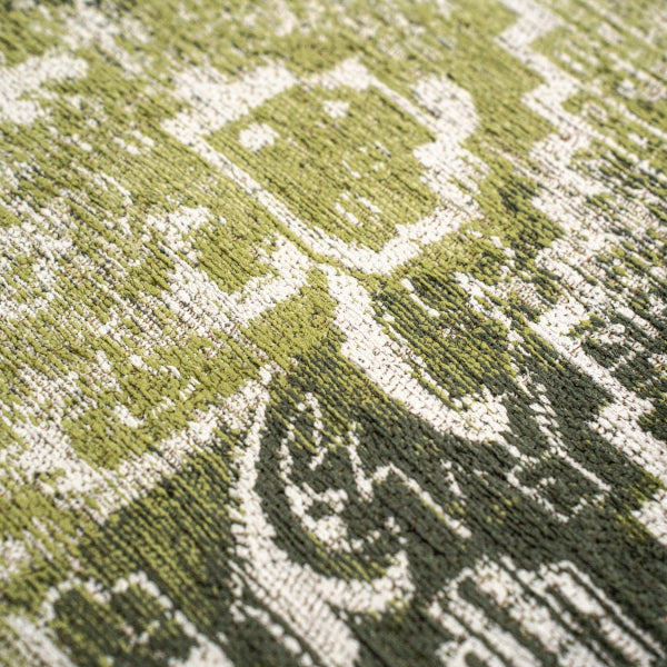 Close-up of textured green and white Louis De Poortere Tabriz rug with intricate traditional patterns