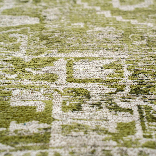 Close up of a green and beige patterned Louis De Poortere Tabriz rug showcasing intricate design and texture