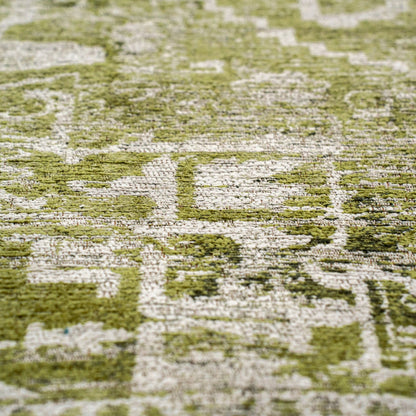 Close up of a green and beige patterned Louis De Poortere Tabriz rug showcasing intricate design and texture