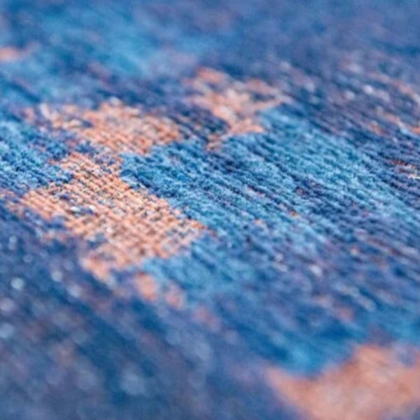 Close-up of the blue and peach woven texture of the Louis De Poortere Venetian Dust rug luxury rug