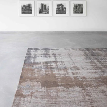 Close-up of Louis De Poortere Venetian Dust rug with abstract muted brown and grey pattern on concrete floor