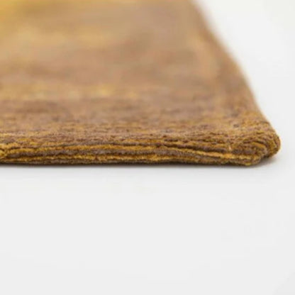 Close-up view of the edge of a Louis De Poortere Venetian Dust rug with rich texture and warm tones