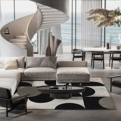 Modern living room with a sectional sofa, chairs, and a dining area with ocean view.