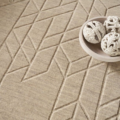 Beige textured Nourison Alessia rug featuring geometric patterns with decorative white carved spheres