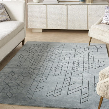 Nourison Alessia rug in grey with geometric pattern placed in a modern living room between sofas