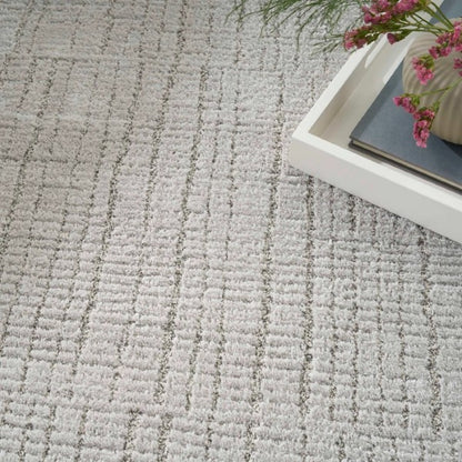 Close-up of textured grey luxury rug from Nourison Andes Rug Collection with decorative tray and flowers
