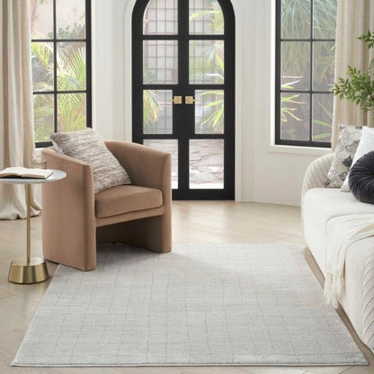 Luxury beige Nourison Andes Rug Collection placed in modern living room with armchair and sofa