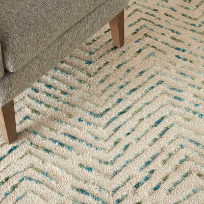 Close-up of Nourison Colorado Rug Geometric Design in beige with blue and green accents under wooden sofa legs