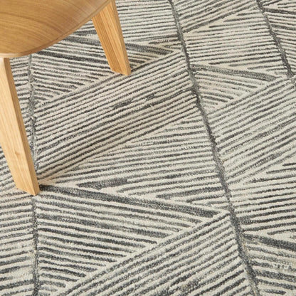 Close-up of Nourison Colorado Rug Geometric Design in grey tones under wooden chair leg