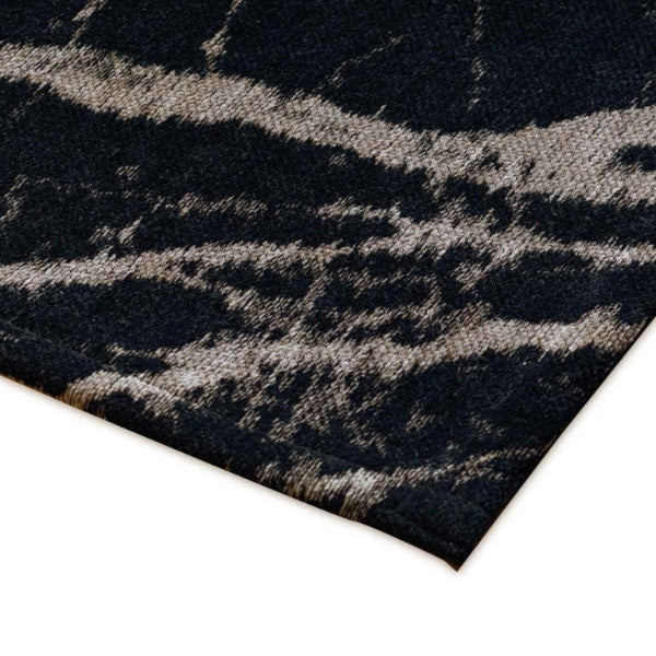 Close-up of a black and gray patterned rug corner on a white background