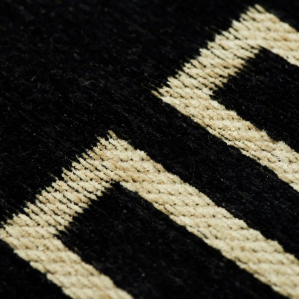 Close-up of a black and beige geometric patterned rug