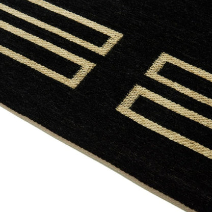 Close-up of a black mat with gold geometric patterns on a white background