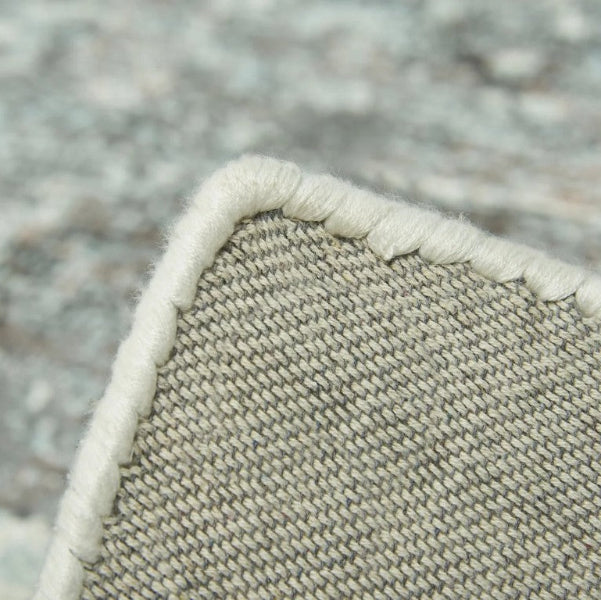 Close-up of the edge of the Sintra Teal Viscose Luxury Rug with detailed stitching and texture