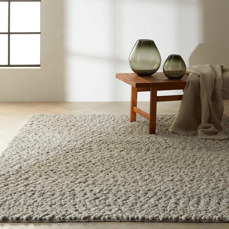 The Calvin Klein Riverstone Rug Collection in soft grey, enhancing modern home interiors with texture and style.