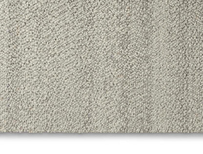 The Calvin Klein Riverstone Rug Collection in soft grey texture, perfect for luxury home interiors