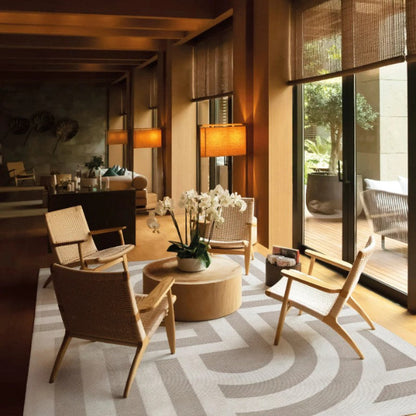 Modern living room with wooden chairs, a coffee table, and decorative elements.