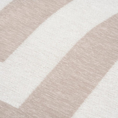 Close-up of a rug with beige and white geometric pattern
