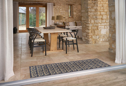 Turtle Mats - ROSEHIP Design floor mat with intricate floral pattern placed in front of a dining area in a stone-walled room