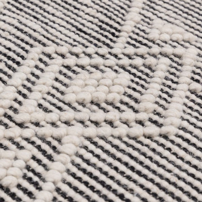 Close-up of Asiatic Boho Collection Asra Rug showcasing textured white patterns on a striped black and white background