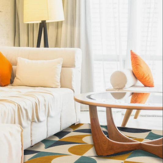 Modern living room with a white sofa, orange and beige pillows, and a glass coffee table.