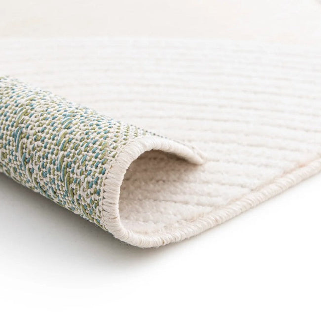 Rolled-up rug with textured pattern on a white background