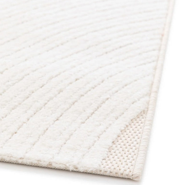 Close-up of a textured white rug corner on a light background